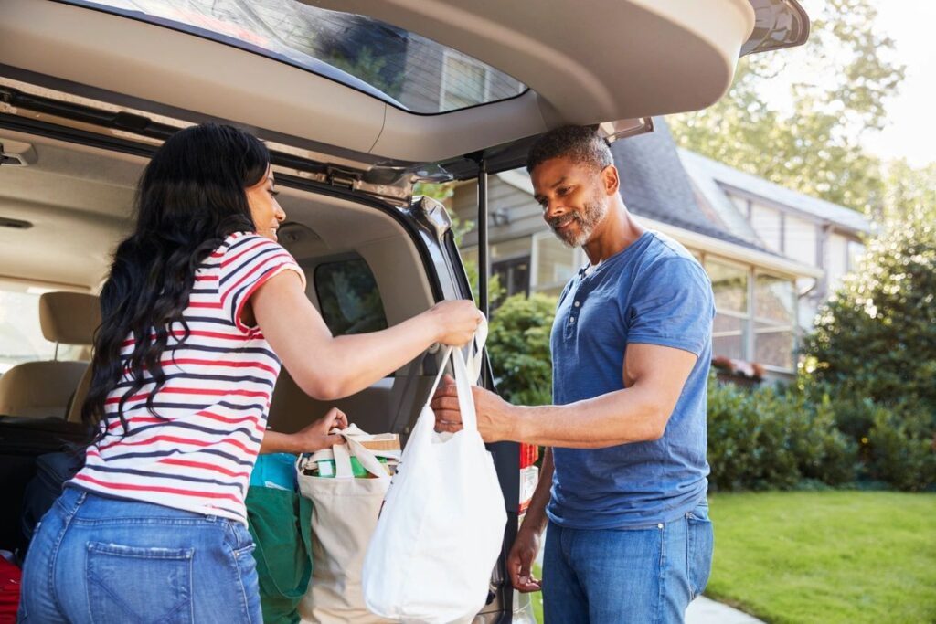 Individual handing senior groceries for care package