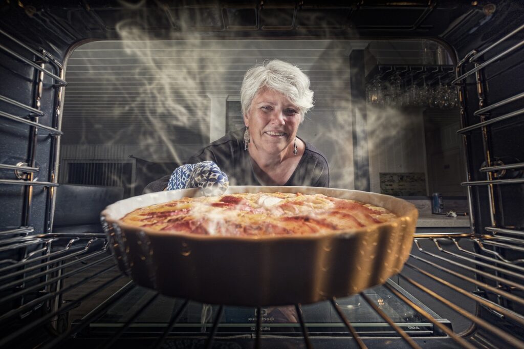 Elderly woman baking delicious apple pie.