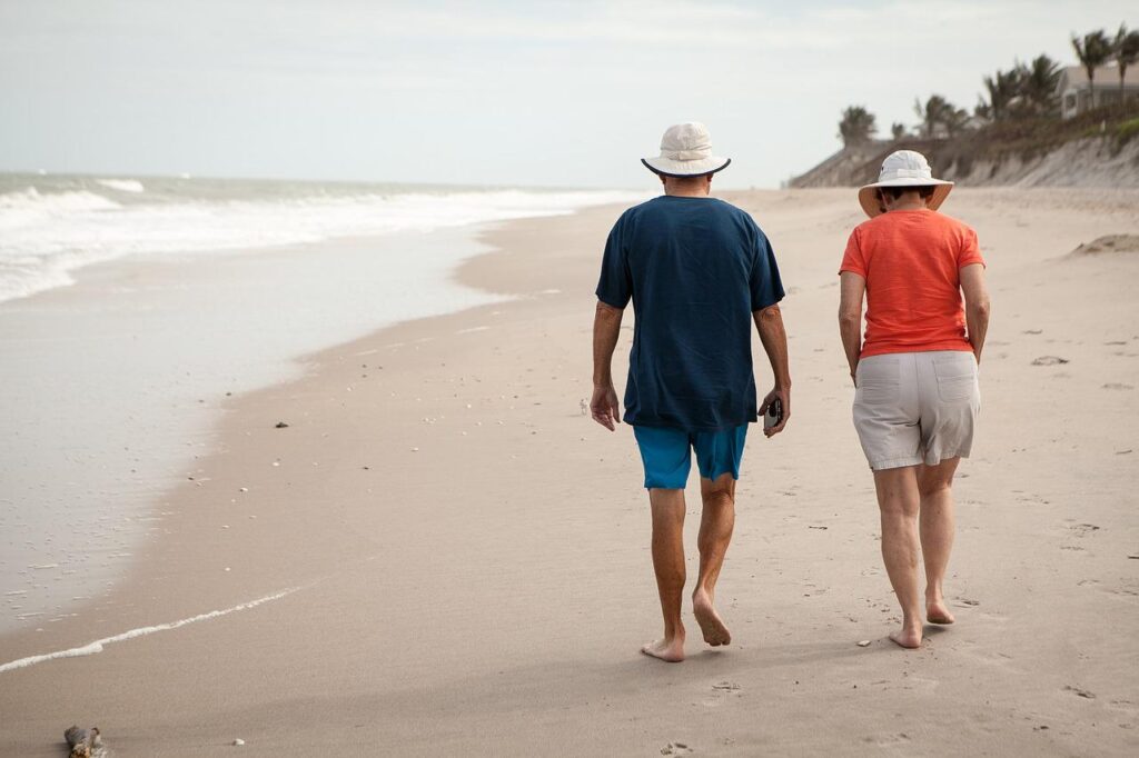 where to live in retirement; elderly couple walking on beach